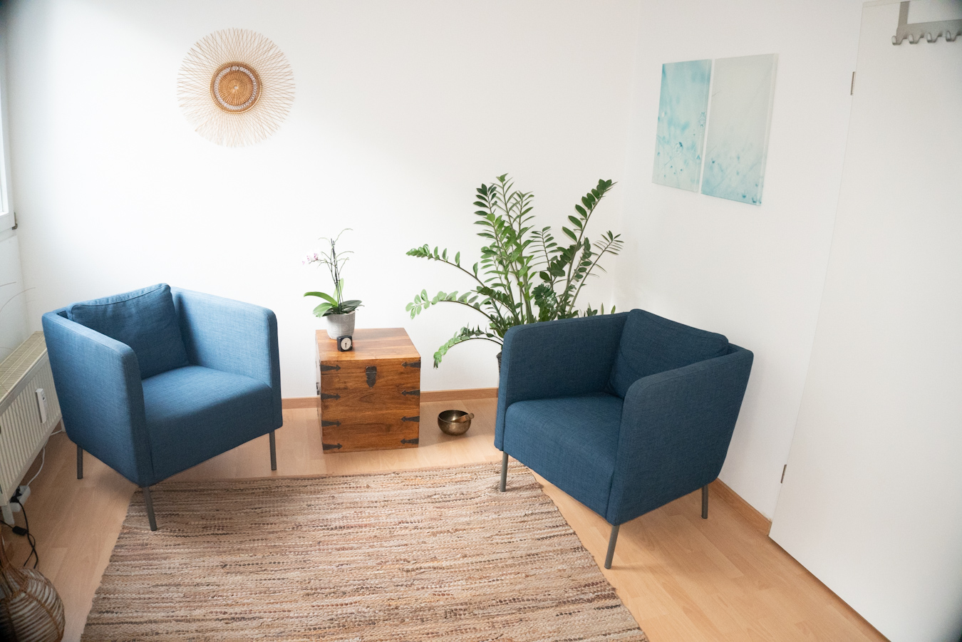 Praxisraum 2 aus anderer Perspektive mit zwei blauen Sesseln und einem Tisch.