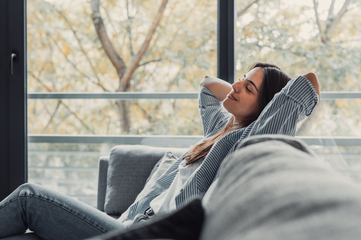 Ratgeber Entspannte Frau auf dem Sofa – Symbolbild für Selbstregulation und ein beruhigtes Nervensystem.
