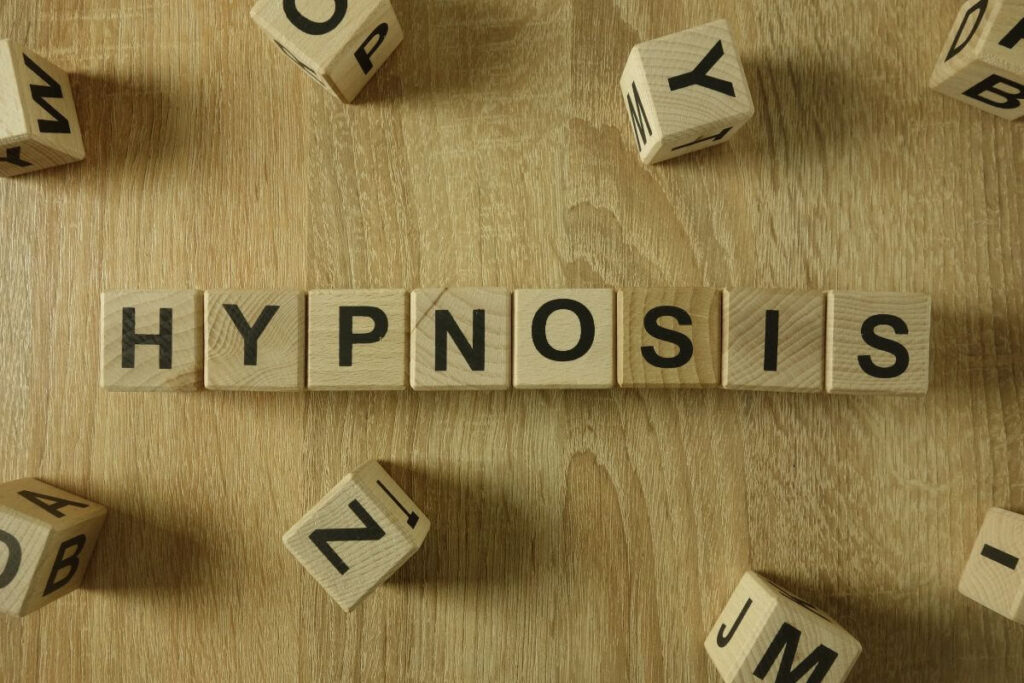 Holzwürfel mit dem Schriftzug „Hypnosis“ als Symbol für Hypnosetherapie und innere Prozesse