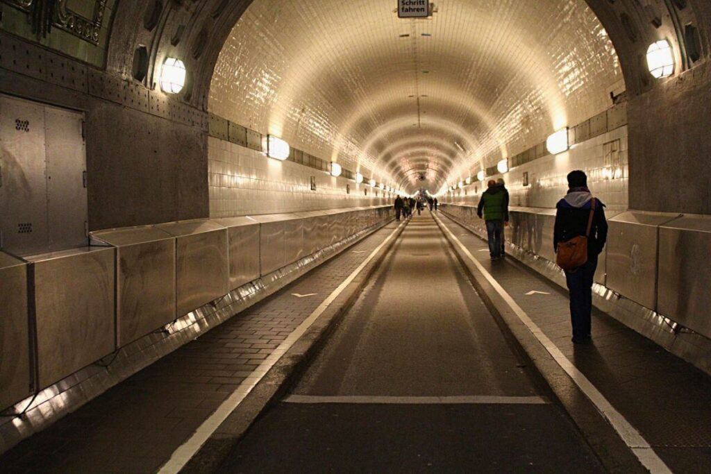 Menschen gehen durch einen langen, engen Tunnel – symbolisches Bild für Klaustrophobie und Raumangst.